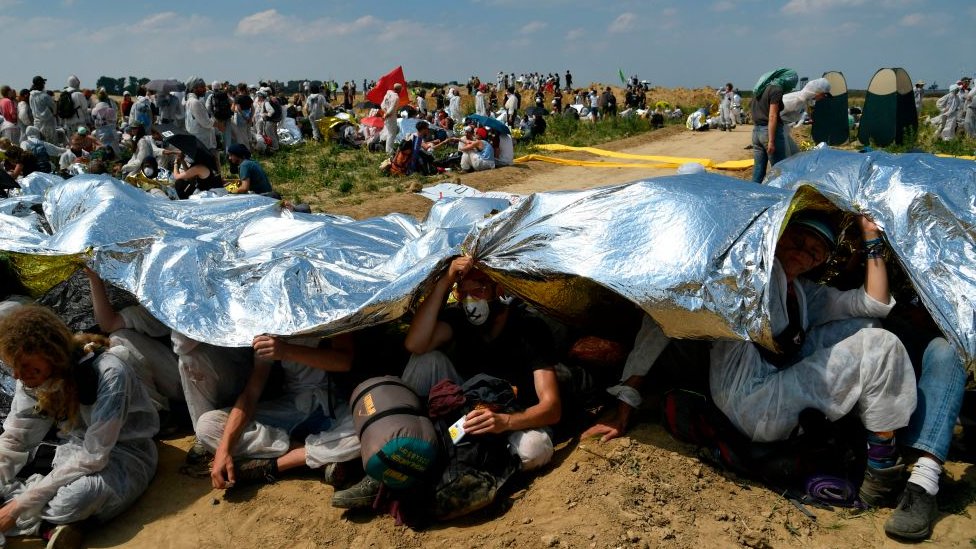 Активисты укрываются от солнца фольгированным одеялом