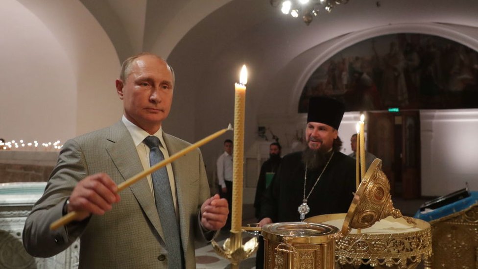 Vladimir Putin, el presidente de Rusia, encendiendo unas velas en un templo ortodoxo.