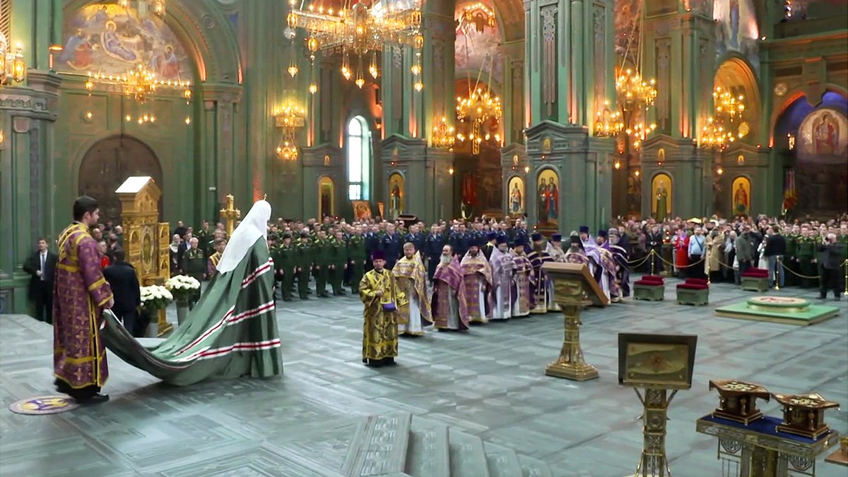 Padre Cirilo, em vestes verdes, em uma cerimônia recente assistida por militares