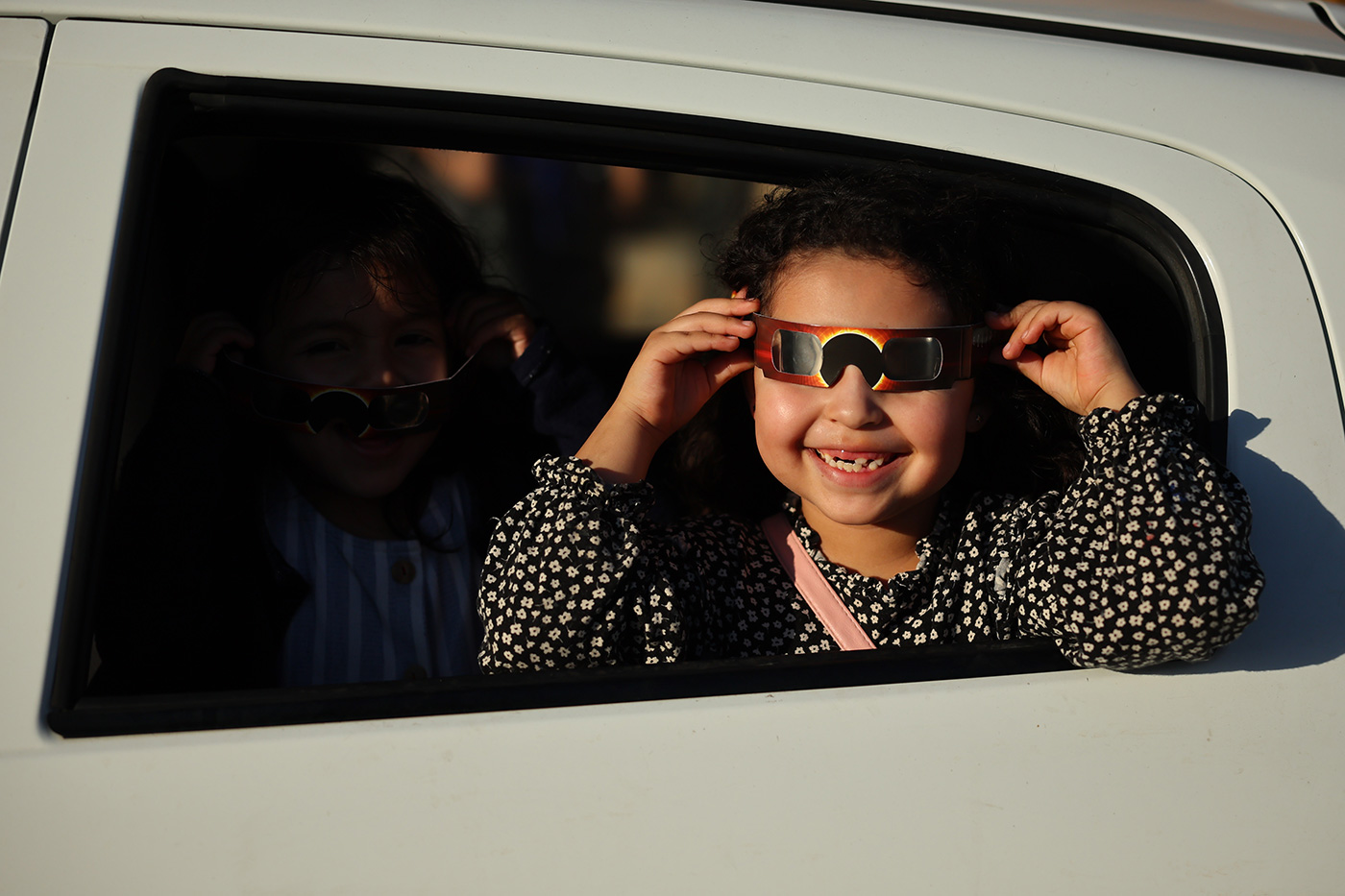 A girl poses with her glasses to see the eclipse from a car ahead of the eclipse in Mazatlan, Mexico - 7 April 2024 (Hector Vivas/Getty Images)
