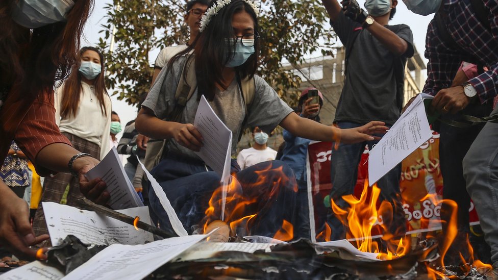 محتجون يحرقون نسخا من الدستور.