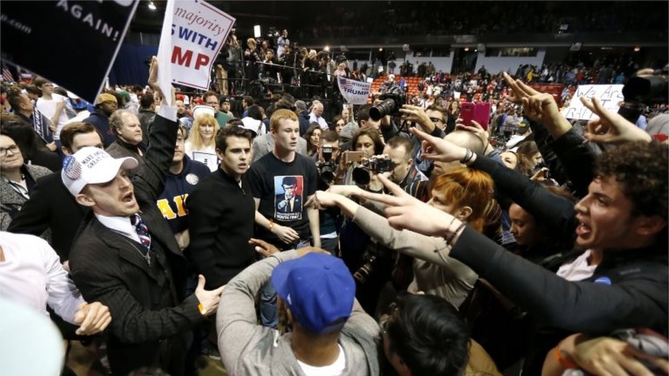 Сторонники кандидата в президенты от республиканцев Дональда Трампа (слева) сталкиваются с протестующими после того, как митинг в кампусе Университета Иллинойса в Чикаго был отменен из-за проблем безопасности Пятница, 11 марта 2016 г.