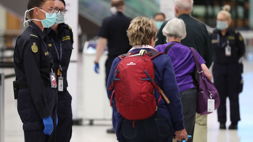 Border officials and travellers at an Australian airport