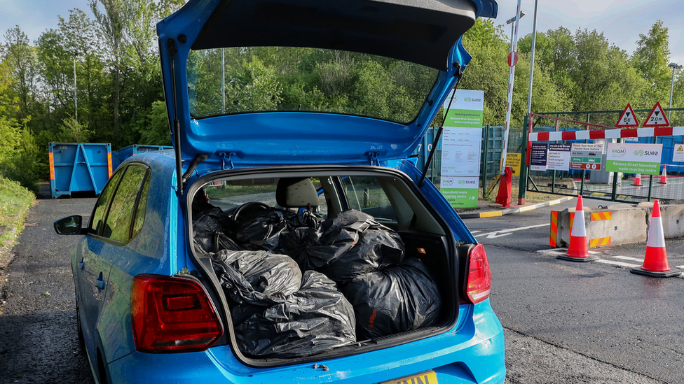 Автомобильный багажник, полный мешков для мусора, на кончике