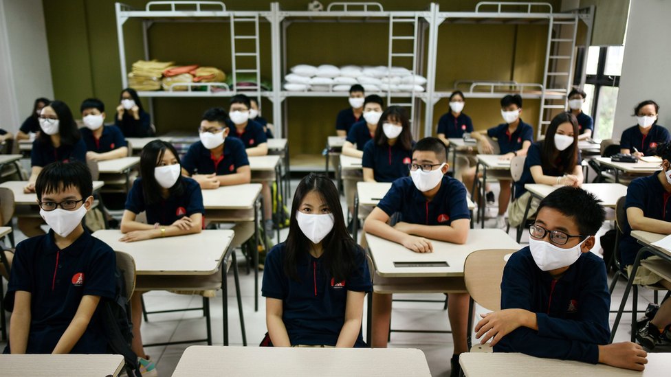 Pelajar di Hanoi memakai masker.