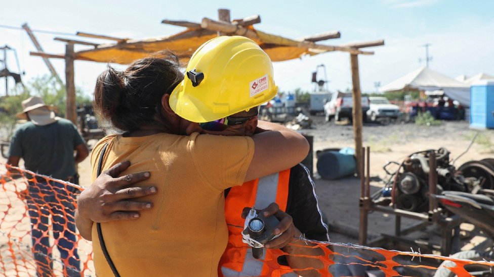 Sergio Martínez Valdés, hermano de uno de los mineros, se abraza con su esposa.
