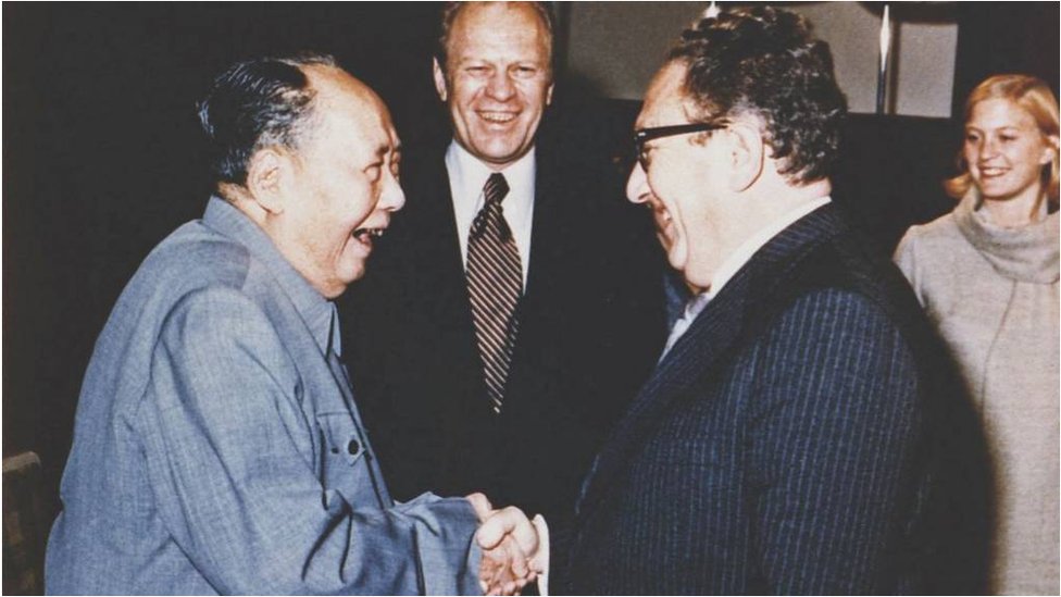 1975年訪問北京時，毛澤東和基辛格握手，福特總統（中）當時站在身旁看著。