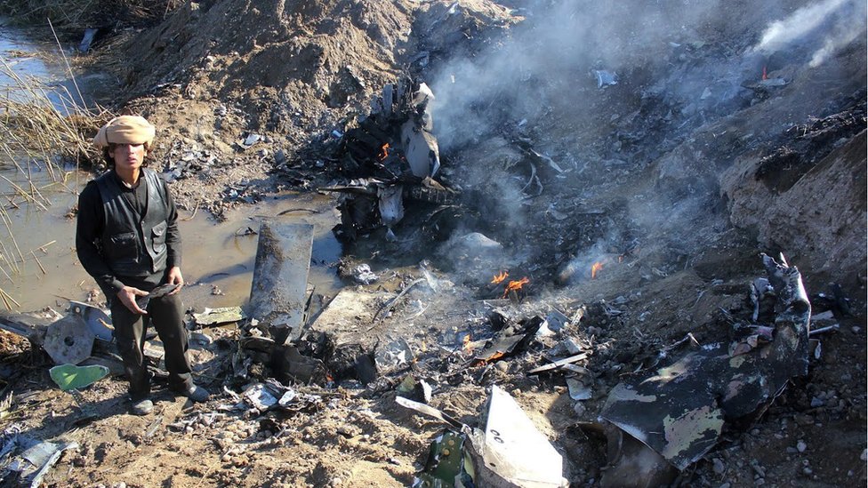 Combatiente de EI frente al avión de combate jordano derribado