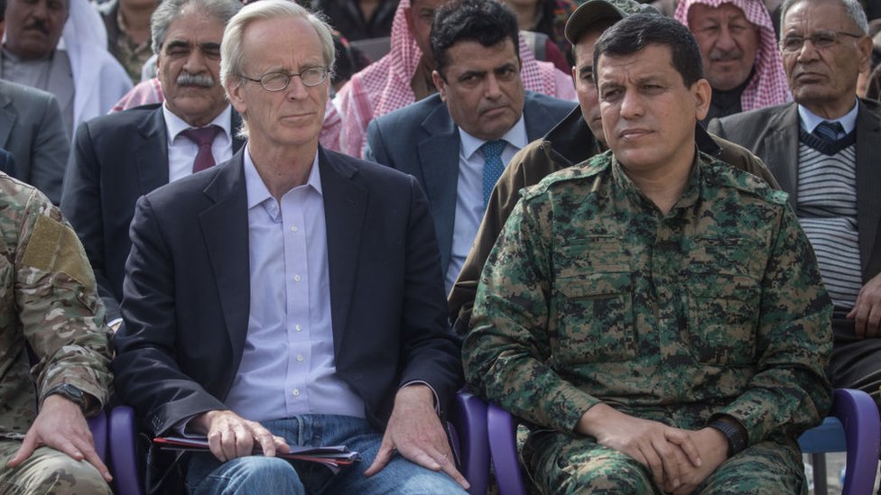 William V. Roebuck (solda) ve SDG komutanı Mazlum Kobani (sağda) ile birlikte Deyr ez Zor'da IŞİD'in Baguz'dan çıkarılmasının ilan edildiği törene katılıyor (23 Mart 2019)