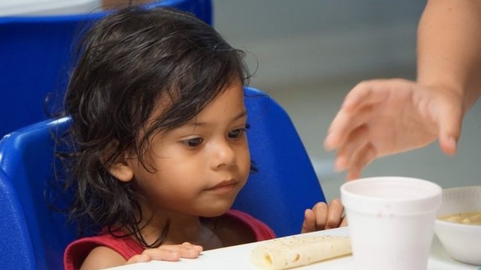 Una niña mira un vaso de sopa en un centro de detención de inmigrantes en la ciudad fronteriza de McAllen, en Texas.