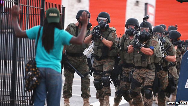 Изображение содержит ненормативную лексику) Демонстранты полиции направляются из делового района в близлежащие районы 11 августа 2014 года в Фергюсоне, штат Миссури.