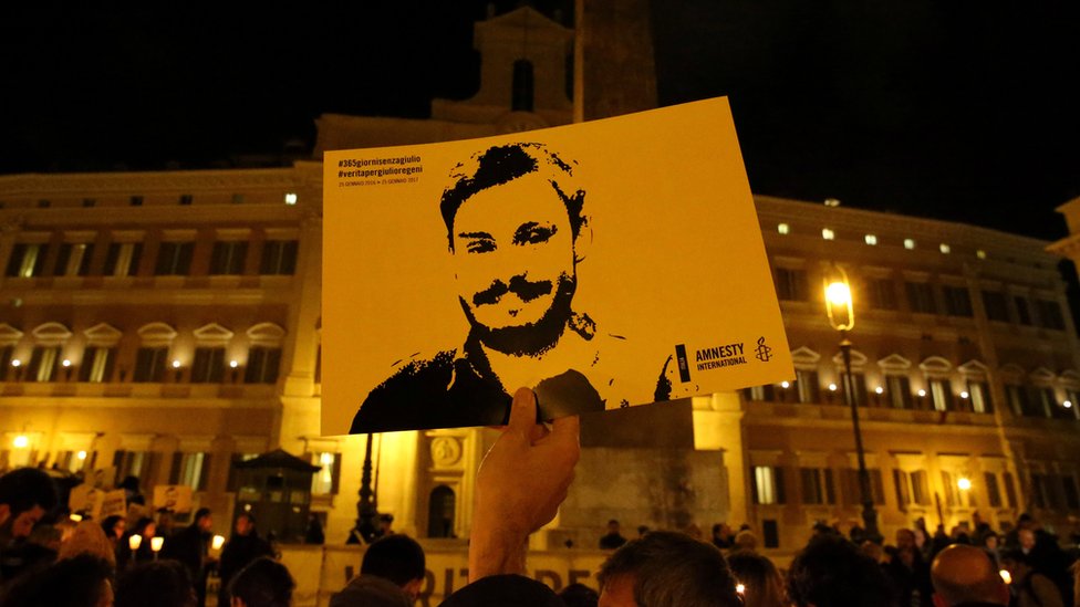 Табличка с лицом Регени во время демонстрации