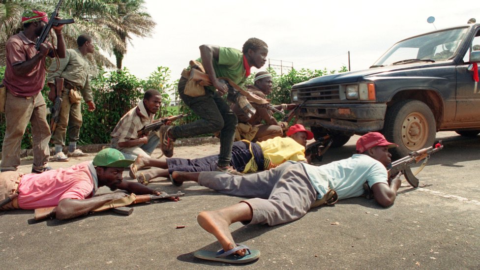 Повстанцы, верные полководцу Чарльзу Тейлору из Национального патриотического фронта Либерии (НПФЛ), занимают позицию за грузовиком 30 мая 1990 г.