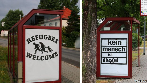 Два плаката: на одном написано «Беженцы приветствуют», а на другом - «Никто не является незаконным»