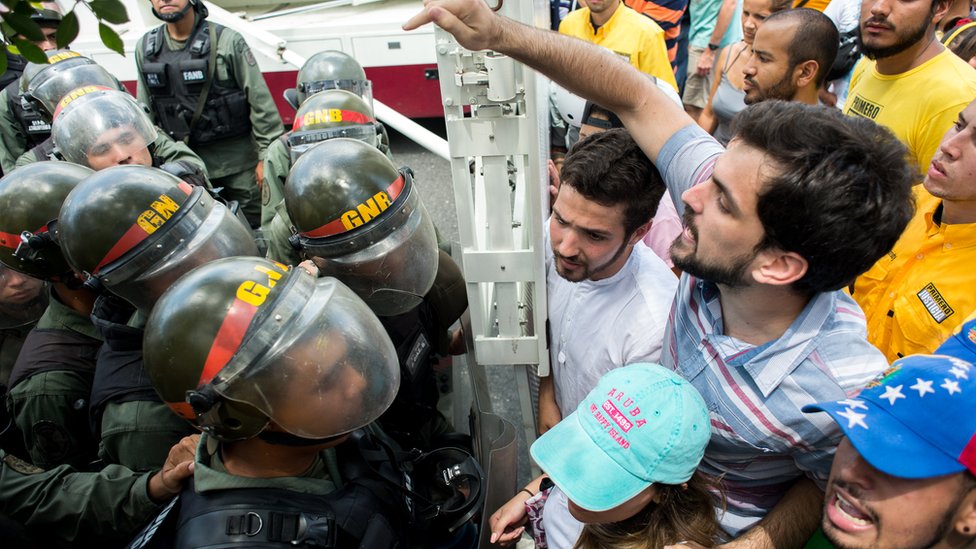 Las dos marchas suponen un reto de seguridad para las fuerzas del orden. Manifestantes frente a la policía.