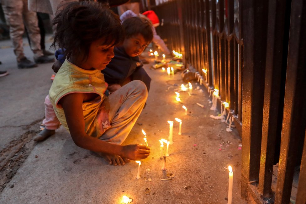 أطفال يضيئون الشموع عند بوابة مدخل كاتدرائية القلب المقدس في دلهي ، الهند. الصورة: 24 ديسمبر 2020