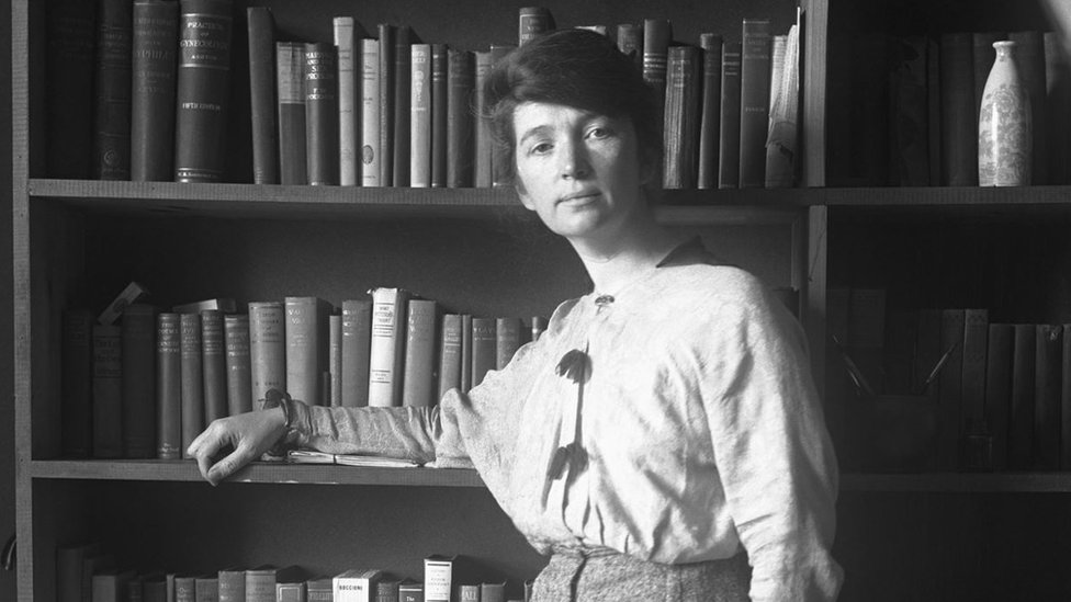 Margaret Sanger em frente a livros