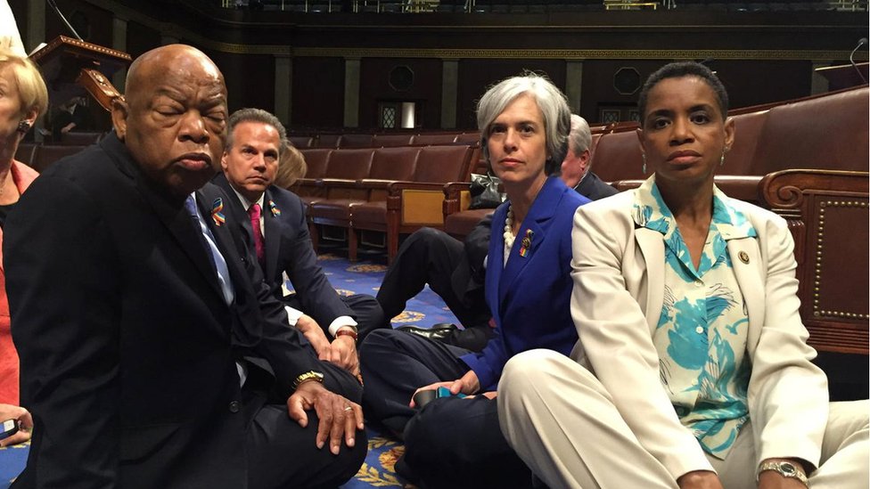 Miembros de la Cámara de Representantes sentados en el suelo para exigir acción en materia de legislación sobre las armas.