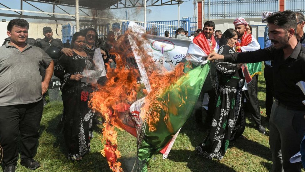 متظاهرون يحرقون العلم الإيراني