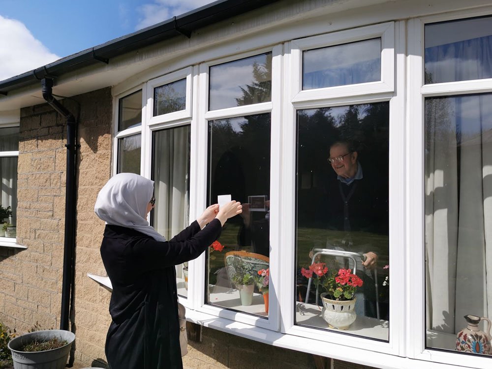 Woman shows a scan image to a man through a window