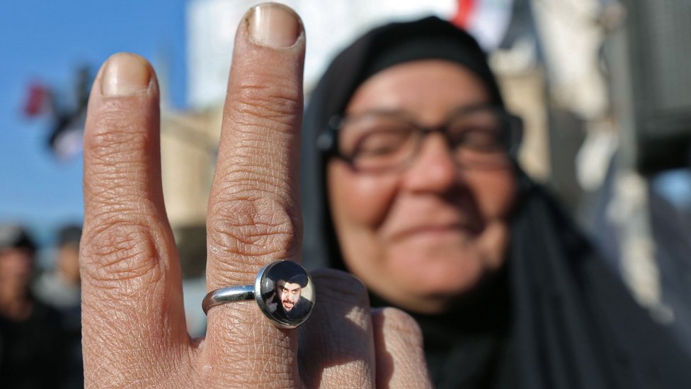 Иракский антиправительственный протестующий в Багдаде демонстрирует кольцо с портретом Моктады аль-Садра (20 ноября 2019 г.)