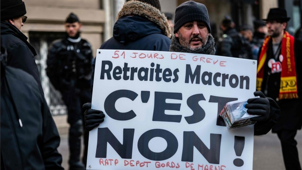 Мужчина с плакатом с надписью «Пенсии Макрону: это нет» принимает участие в демонстрации в Париже 24 января 2020 г.