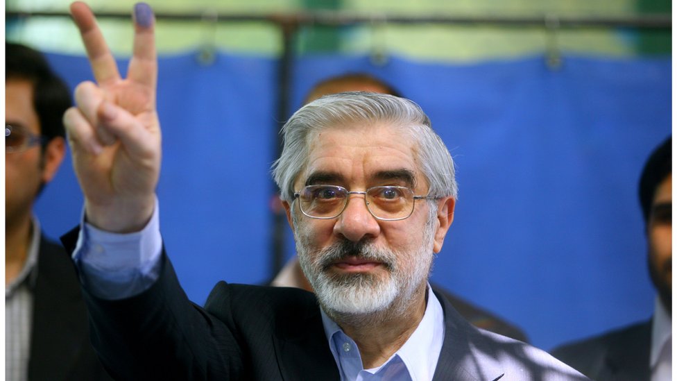 Former Iranian prime minister and presidential candidate Mir Hossein Mousavi flashes the V sign after casting his vote at a polling station at the Ershad mosque on 12, 2009 in Tehran, Iran