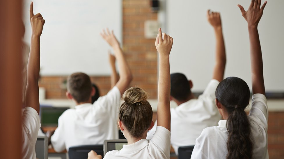 дети в классе поднимают руки