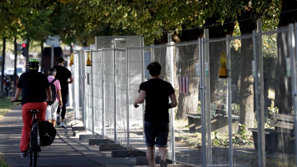 Люди пробираются мимо забора на Терезиенвизе, в районе Октоберфеста, в Мюнхене, Германия, в среду, 14 сентября 2016 г.