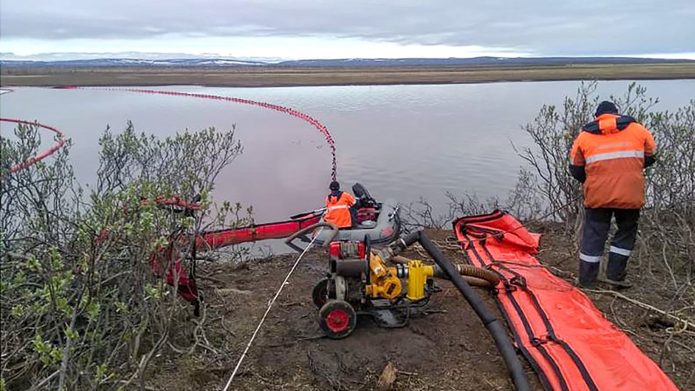 Floating booms trap red diesel flowing downstream