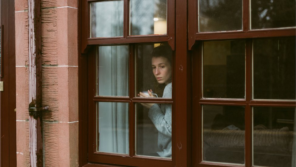 Женщина смотрит в окно