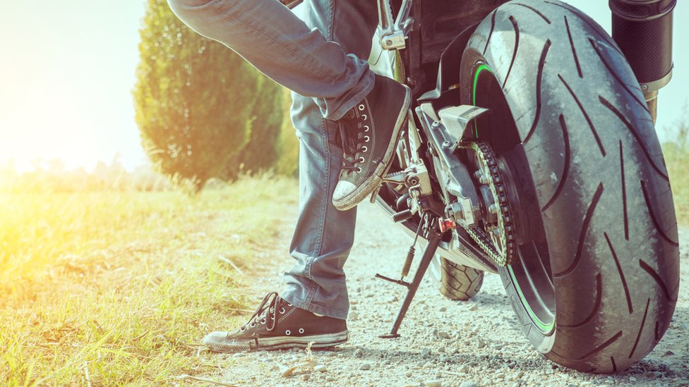 Мотоциклист в джинсах и кроссовках