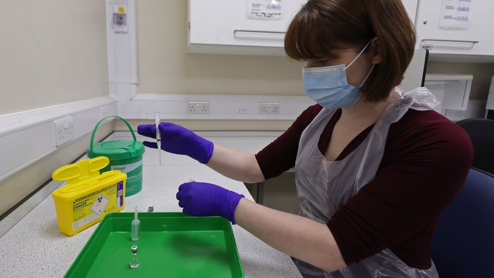 Техник аптеки NHS в Королевской свободной больнице в Лондоне моделирует приготовление вакцины Pfizer для поддержки обучения персонала перед развертыванием