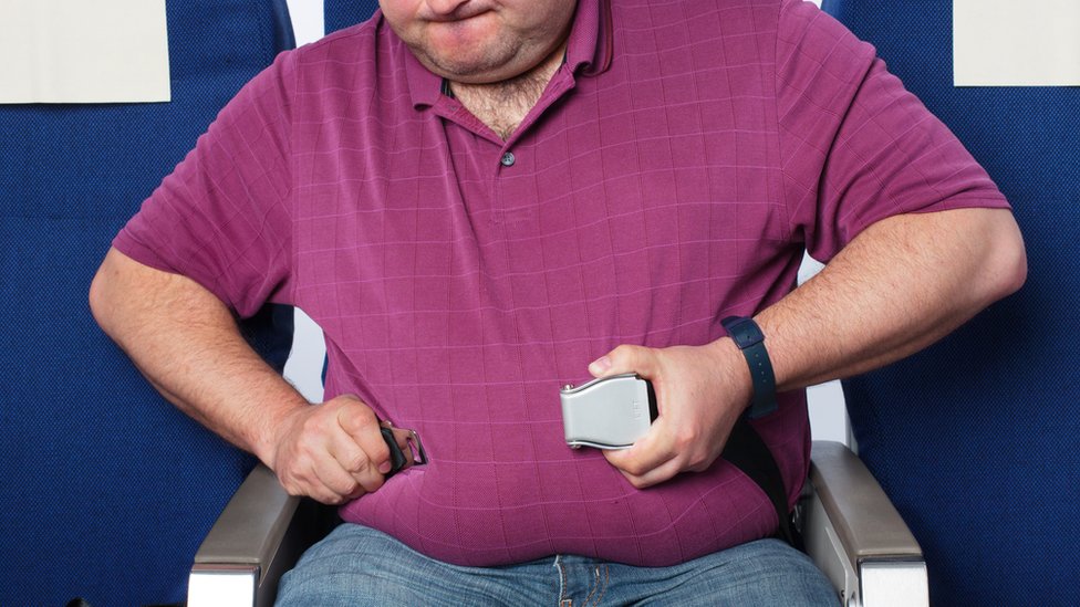 Algunos pasajeros necesitan una extensión de cinturón de seguridad. Un pasajero con el cinturón de seguridad