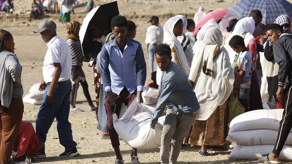 Tigray people, fled due to conflicts and taking shelter in Mekelle city of the Tigray region, in northern Ethiopia, receive the food aid distributed by United States Agency for International Development (USAID) on March 8, 2021.