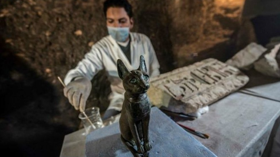 一名埃及考古學家為貓女神的青銅雕像清理