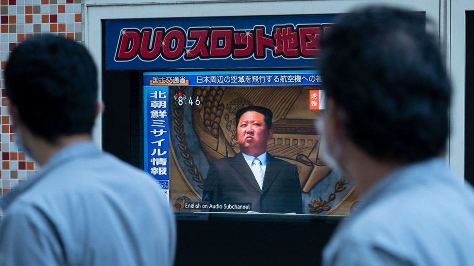 La gente en Tokio pasa por delante de una pantalla de televisión que muestra a Kim Jong-un