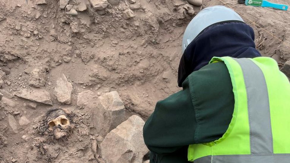 Un arqueólogo trabajando en el sitio de excavación de un entierro prehispánico junto a una momia que se cree que es de la cultura Manchay, que habitó en los valles de Lima entre 1500 y 1000 a. C., en Lima, Perú, el 14 de junio de 2023.