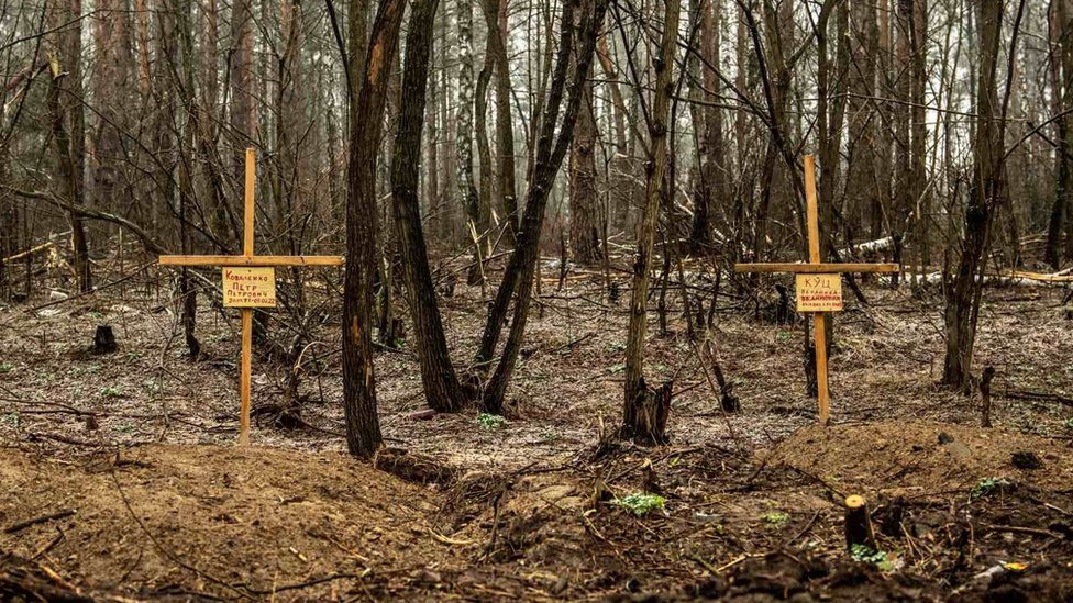 Two small wooden crosses mark the graves of Petro and Veronika