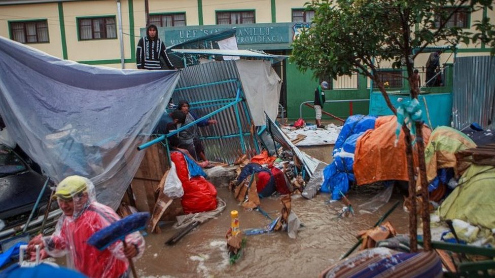Люди возвращают свои вещи во время наводнения, вызванного проливными дождями в Сукре, Боливия, 4 января 2021 года.