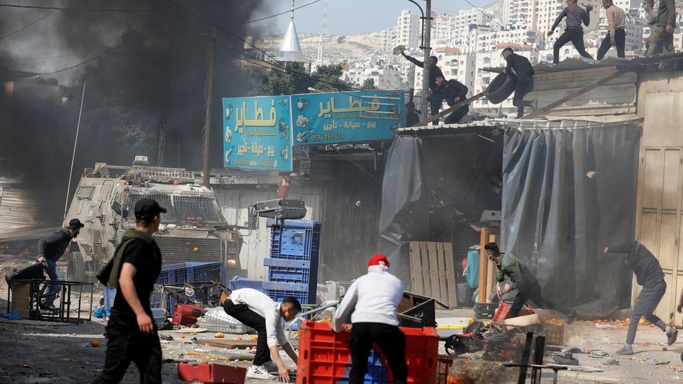 Jóvenes palestinos lanzaban piedras y otros objetos contra los vehículos blindados israelíes que ingresaron a Nablus el miércoles.