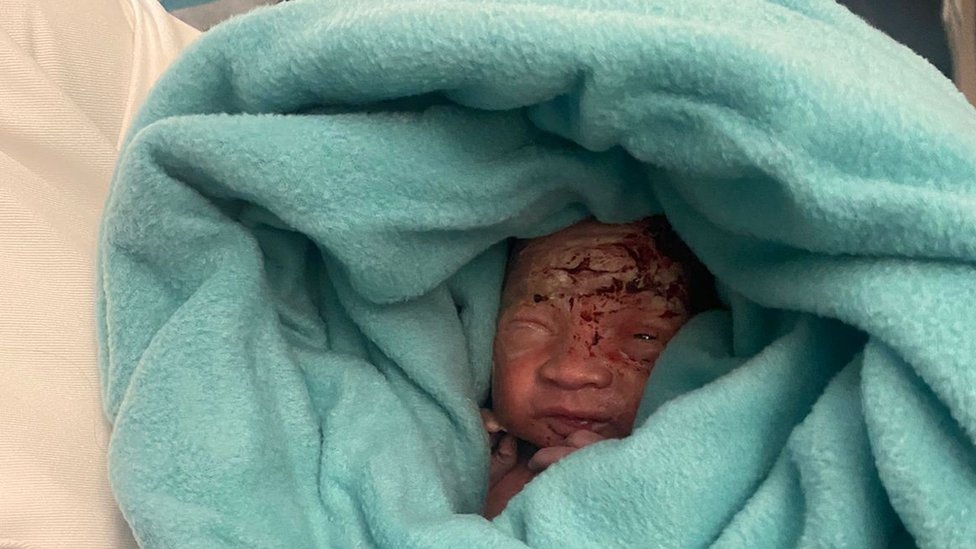 Newborn baby wrapped in a blue blanket