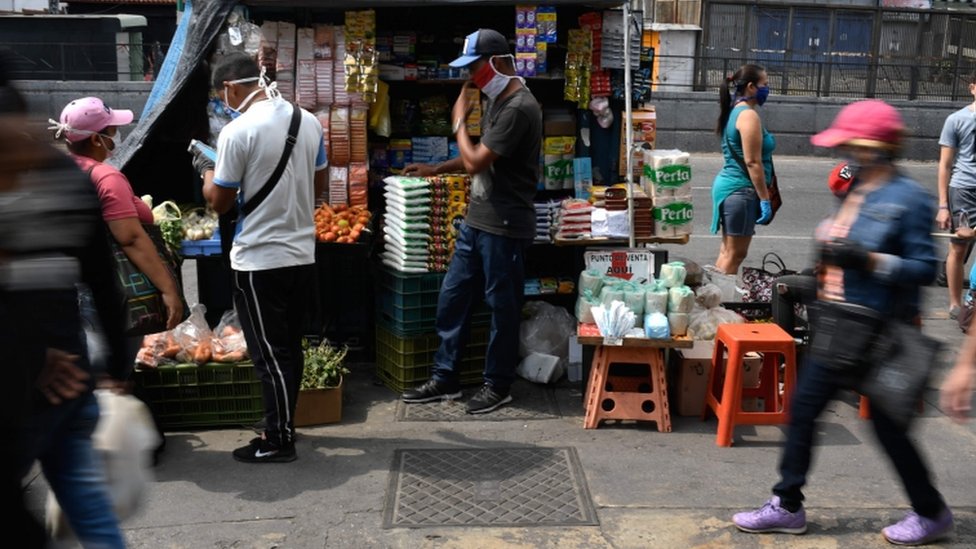 Люди носят маски на рынке в качестве профилактической меры против распространения нового коронавируса COVID-19 в районе Петаре в Каракасе 2 апреля 2020 г.