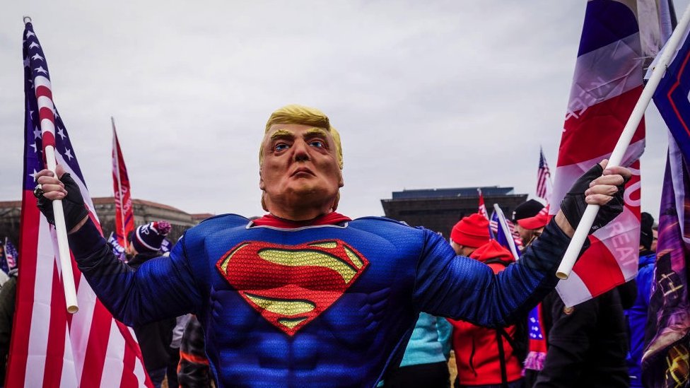 A Trump supporter dressed as Superman and wearing a mask with the face of the former president