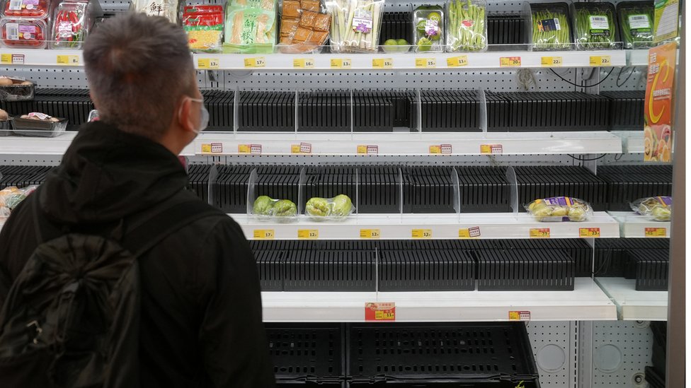 A customer wearing a face mask shops in front of partially empty shelves at a supermarket, following the outbreak of the coronavirus disease (COVID-19), at Sha Tin district, in Hong Kong, China, February 7, 2022.