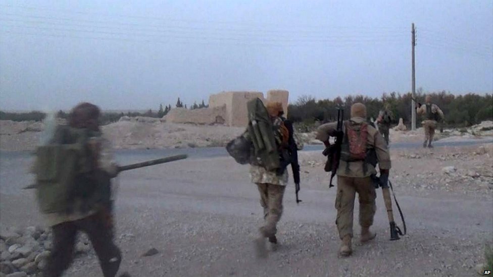 Боевики «Исламского государства» несут свое оружие в городе Карьятайн близ Пальмиры в Сирии - 5 августа 2015 г.