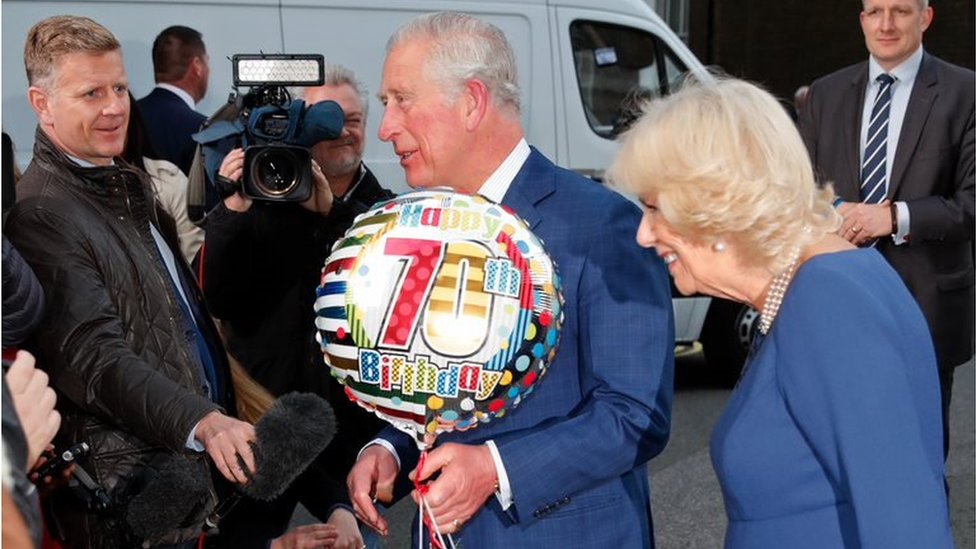 King Charless III holding a a balloon with '70th Birthday' inscribed on it during his 70th birthday celebrations in 2018
