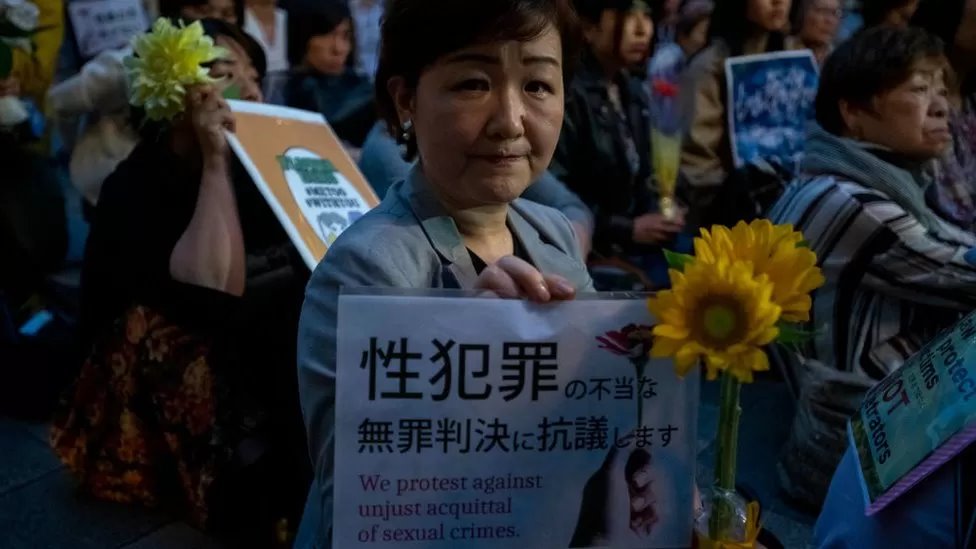 سيدة يابانية تمسك لوحة تطالب بتعزيز قوانين محاربة الجرائم الجنسية