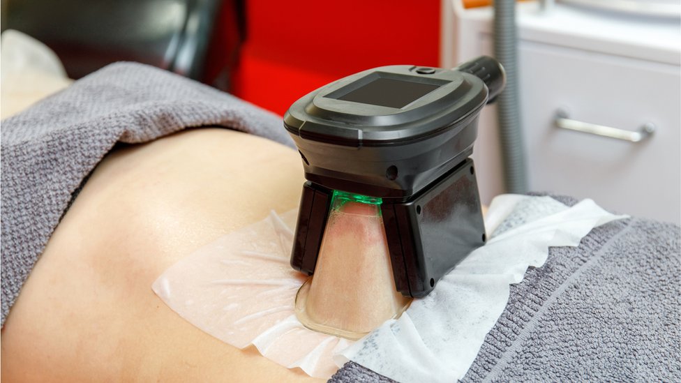 Fat-freezing procedure in cosmetic salon, belly close-up