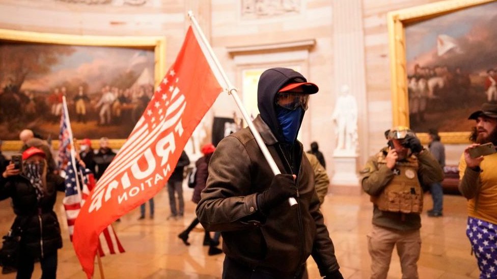 Мятежник в ротонде Капитолия с флагом Трампа